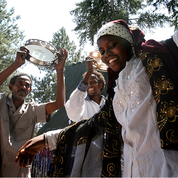 Sahra Bashir (cq), de 16 años, de Somalia, baila al ritmo de música de África Oriental, mientras sus compatriotas somalíes, Bare Munye (cq), de 47 años (a la izquierda), y Bashir Ararso (cq), de 24 años, de la Organización Cultural Sabaree Africa (en el centro), hacen algo de ruido