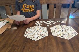 New game with creator holding the new written rules. 