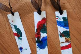 Painted watercolor paper made into bookmarks with ribbon.