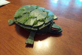 Red eared slider made out of recycled materials and moss on its shell