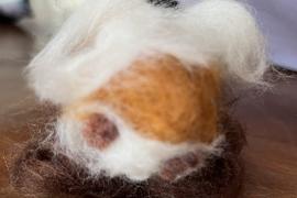 It is a needle-felted representation of a highland cow.