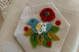 Hexagon with felt and embroidered bird on antique linen