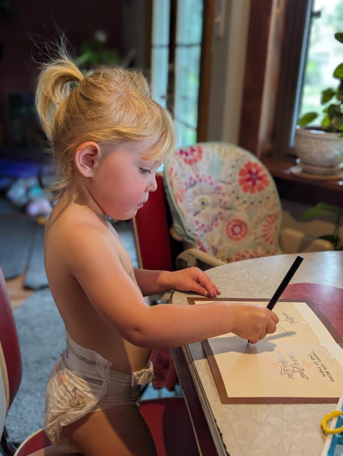 Tillie practicing writing a letter to Grandpa