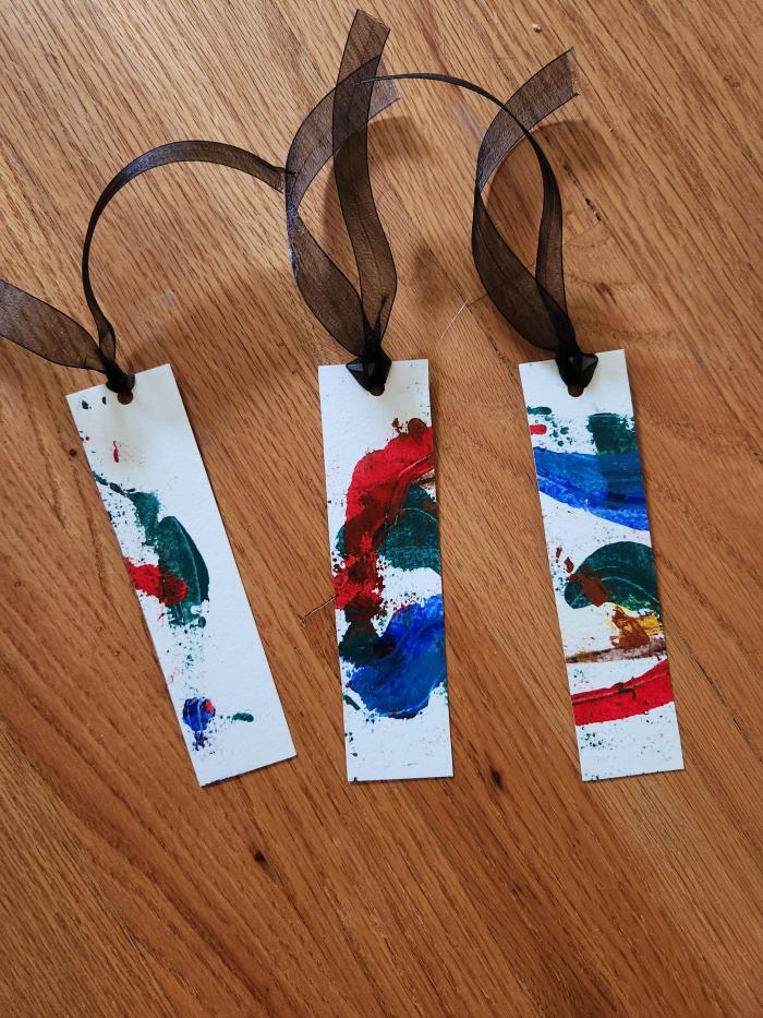 Painted watercolor paper made into bookmarks with ribbon.