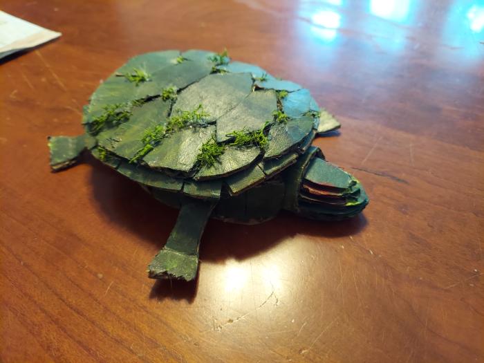 Red eared slider made out of recycled materials and moss on its shell