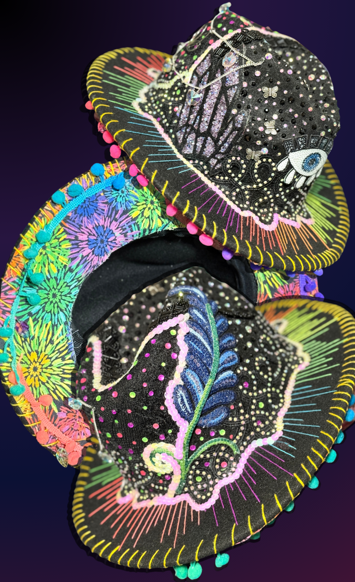 Sombrero de fieltro negro decorado con pedrería, colgantes, apliques de lentejuelas, hilo de bordar arcoíris y ribete de pompones.