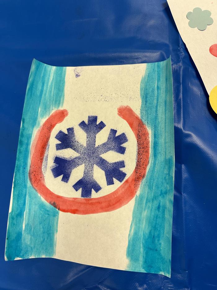 Colorado flag made out of markers and crayola air sprayer with a snowflake in the middle as the “C” for Colorado 