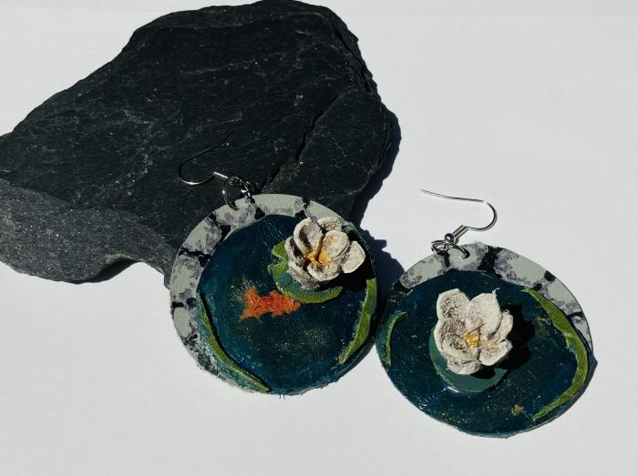 Leather earrings that look like Lilly pads floating on the shore of a lake 