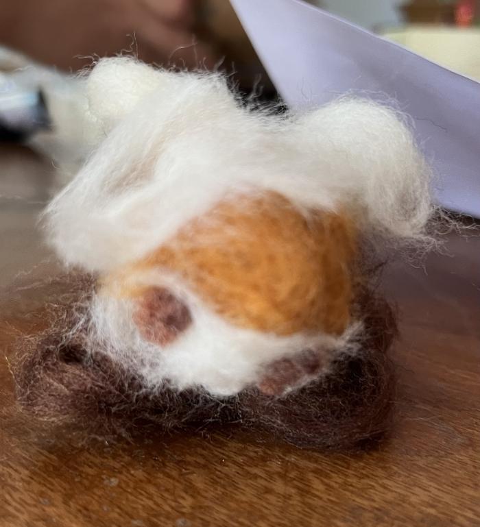 It is a needle-felted representation of a highland cow.