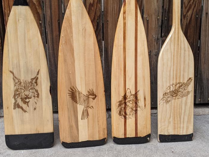 Etched each family members' favorite animal on their canoe paddle.