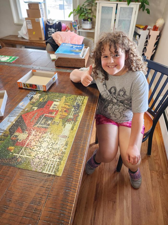 Josie posing by her completed puzzle