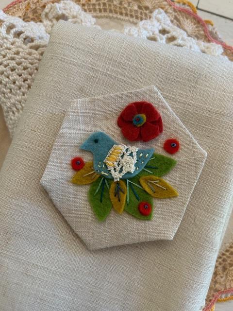 Hexagon with felt and embroidered bird on antique linen